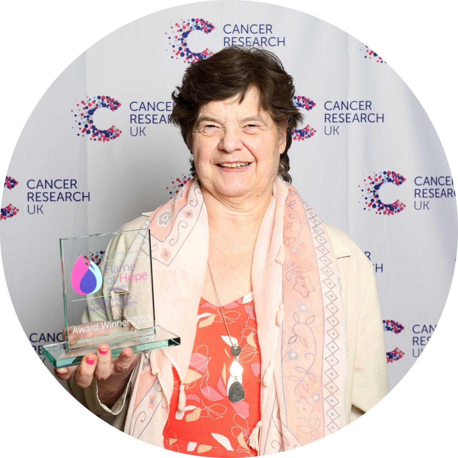 Janice holding her Flame of Hope trophy