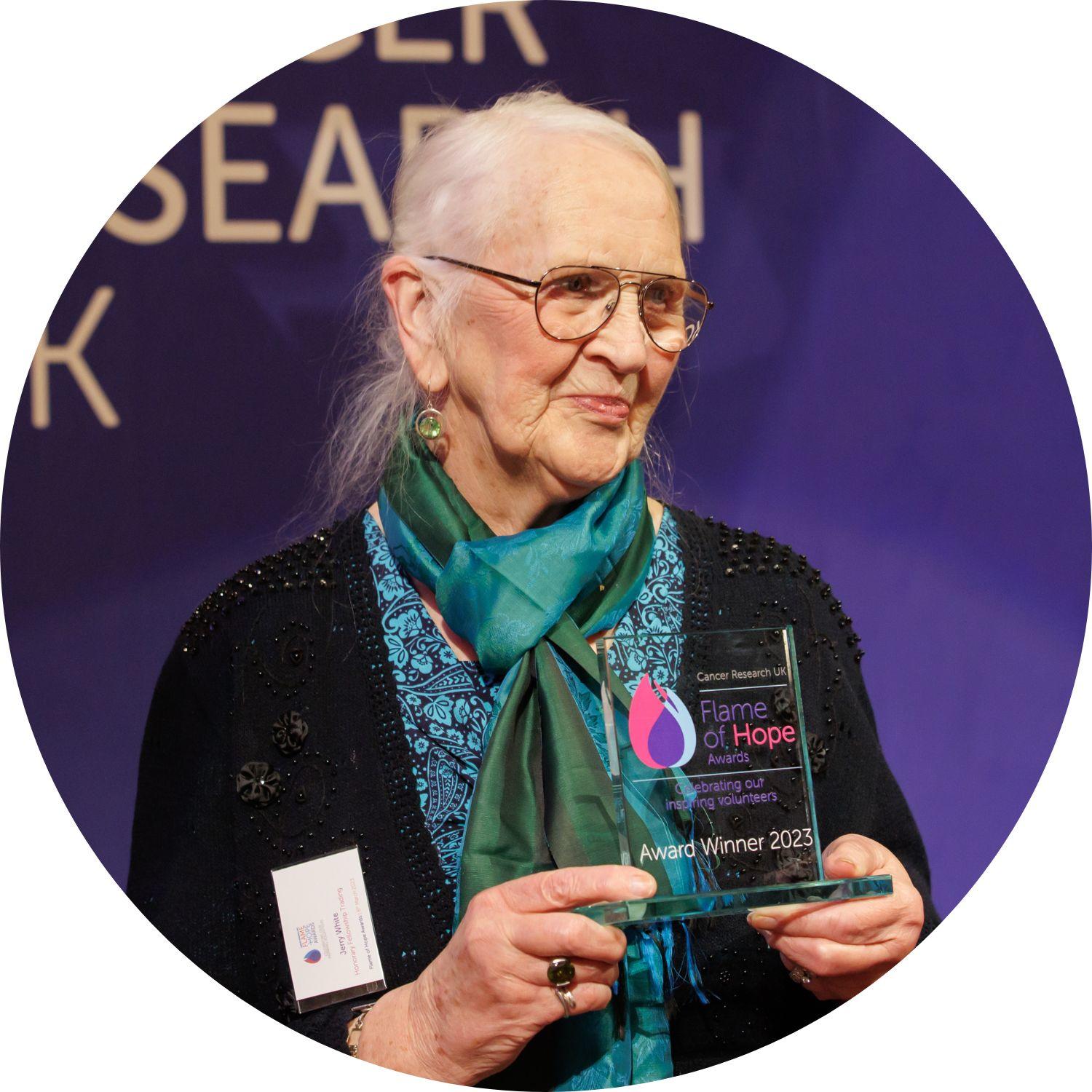 Jerry holding her Flame of Hope trophy