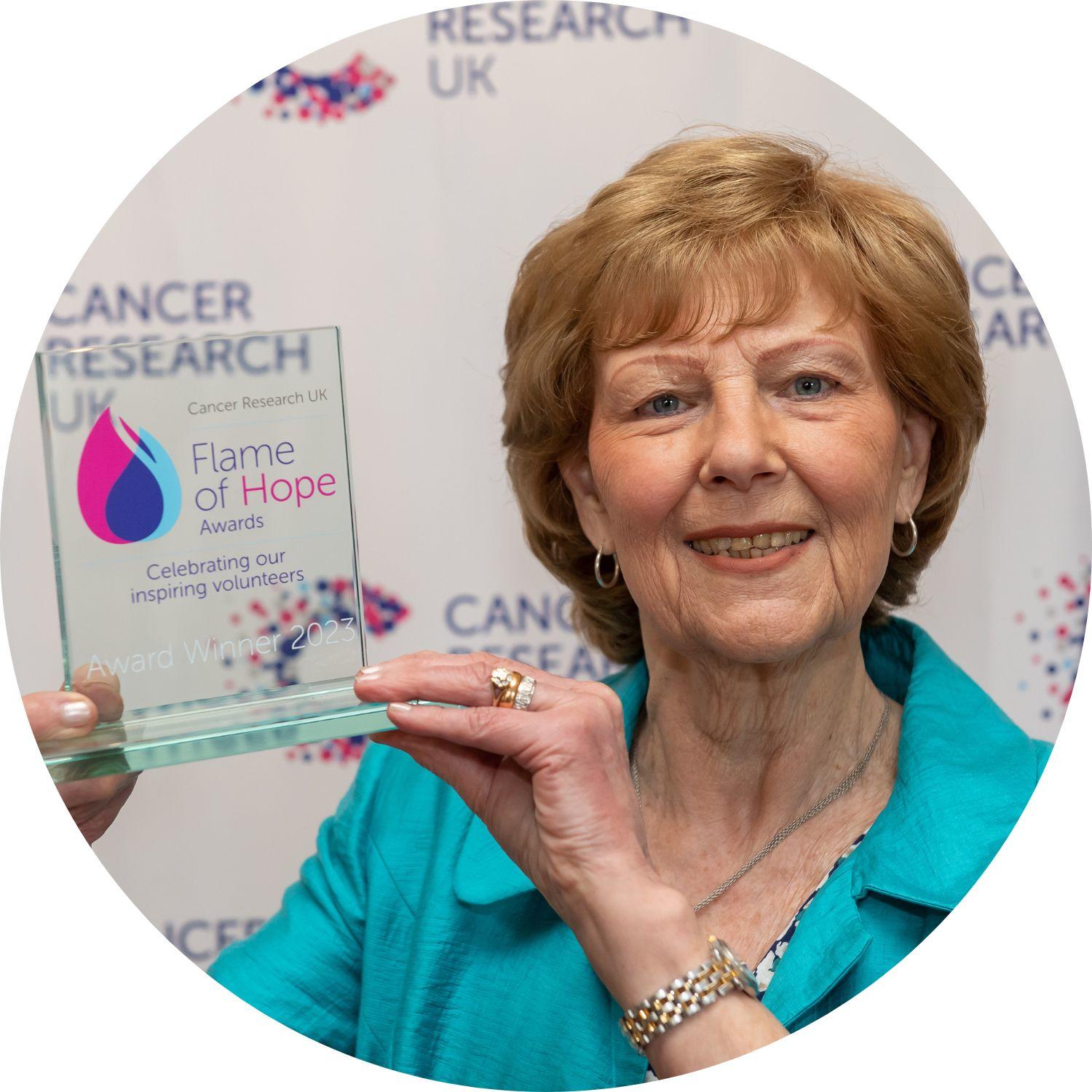 Joan holding her Flame of Hope trophy