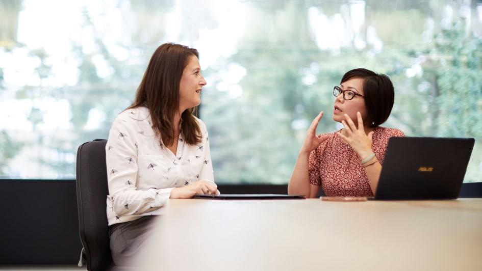 Two people seated having a discussion