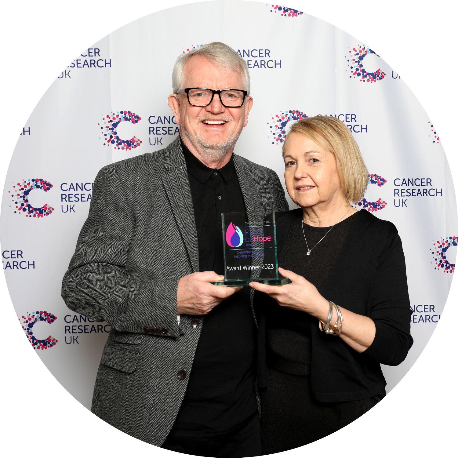 John and Karen holding their Flame of Hope trophy