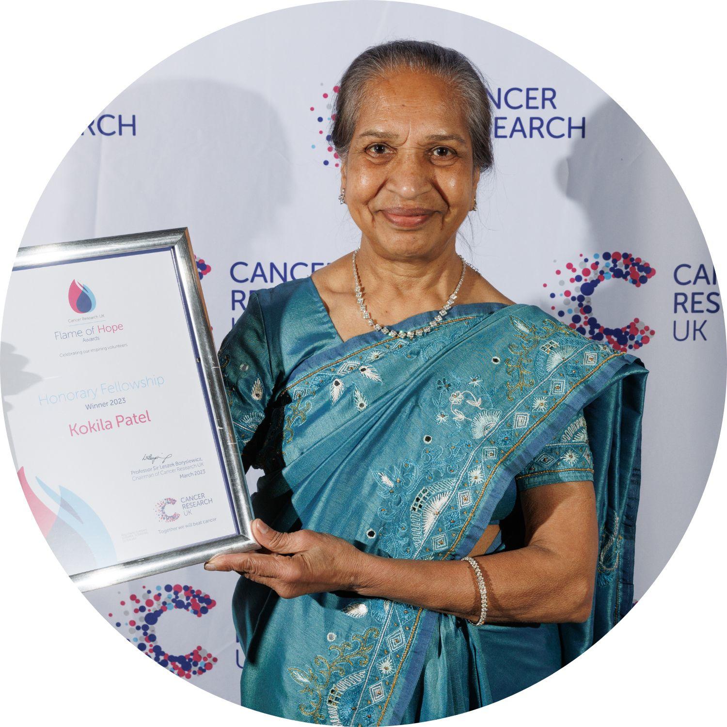 Kokila holding her Flame of Hope certificate