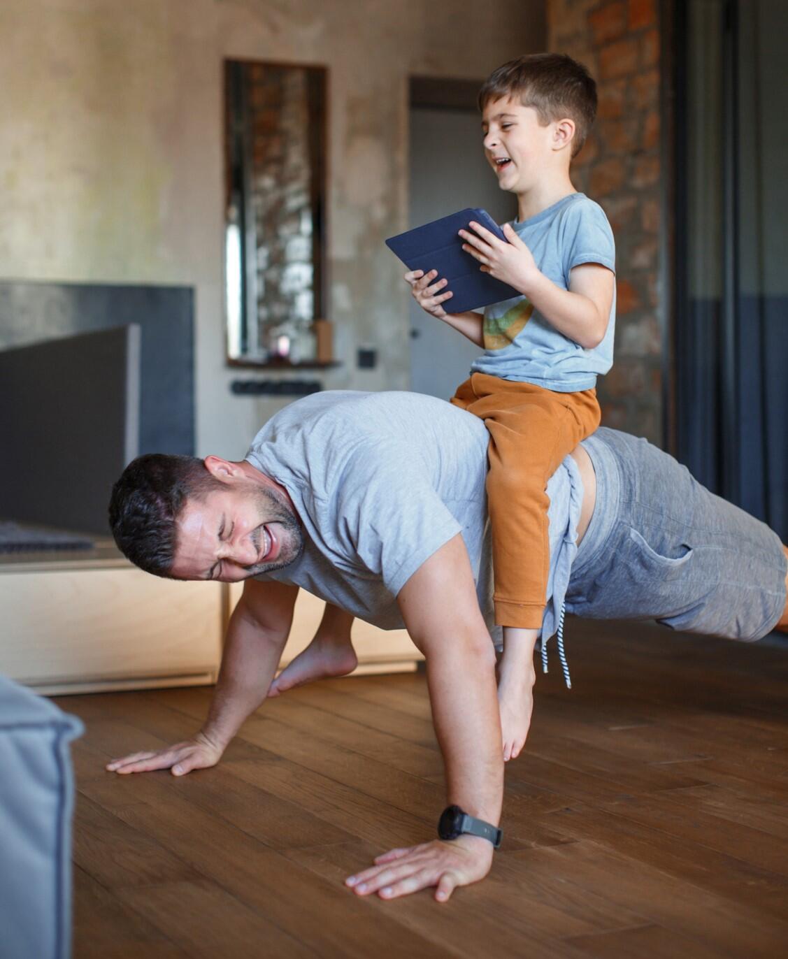 Man doing push-ups with a child on their back