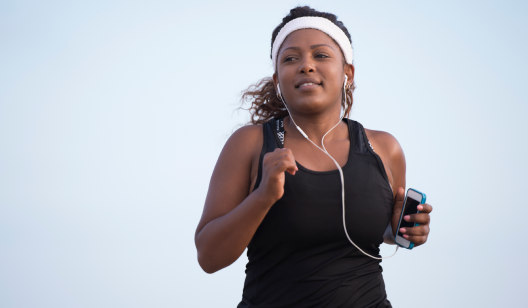 Benefits of Marathon Month Challenge Women running in black top and white sweatband.