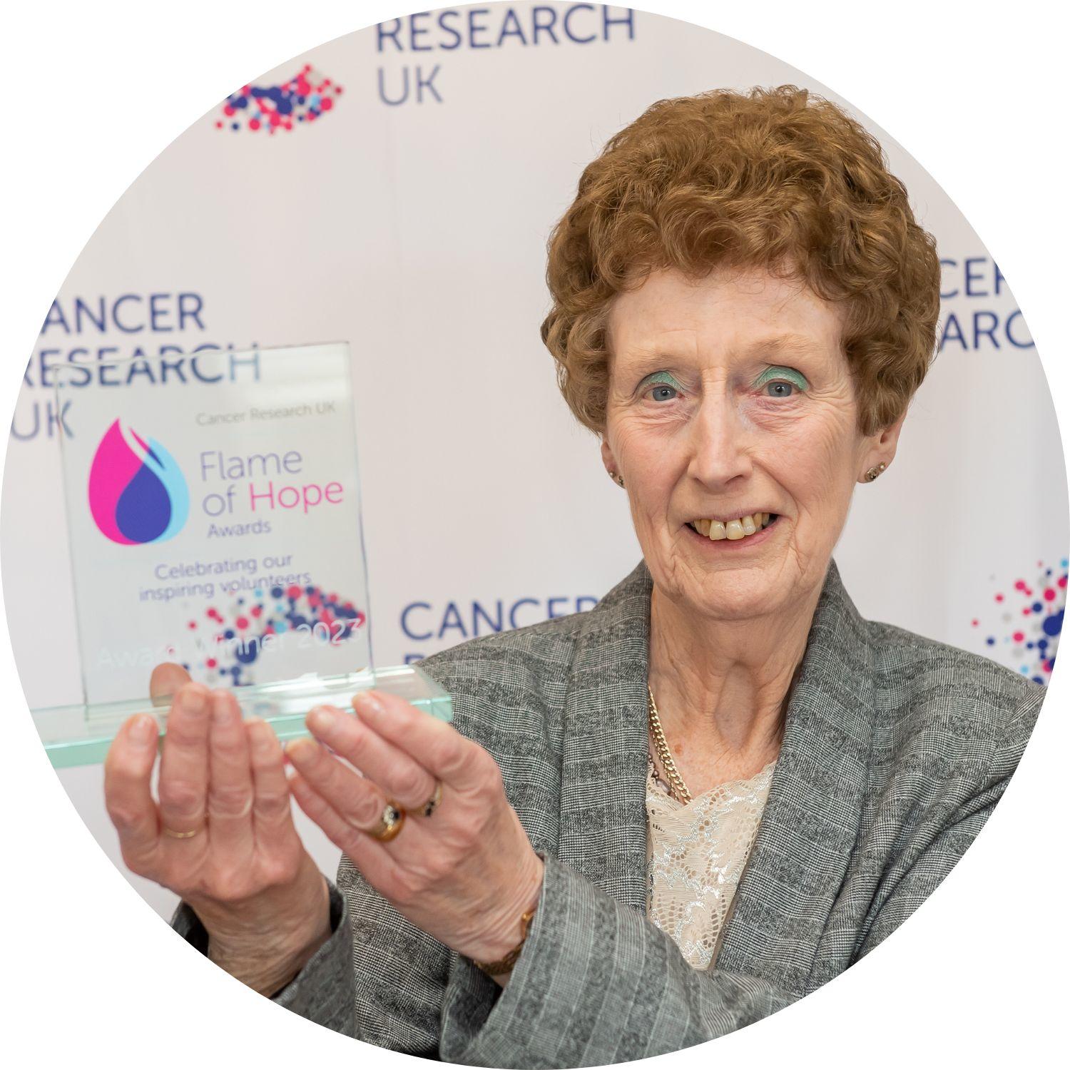 Margaret holding her Flame of Hope trophy