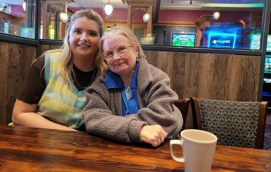 Megan and Angela smiling over coffee