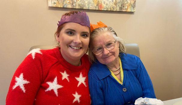 Megan and Angela smiling and wearing hats from a Christmas cracker