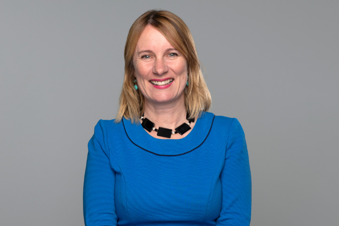 Lady in blue dress smiling at the camera