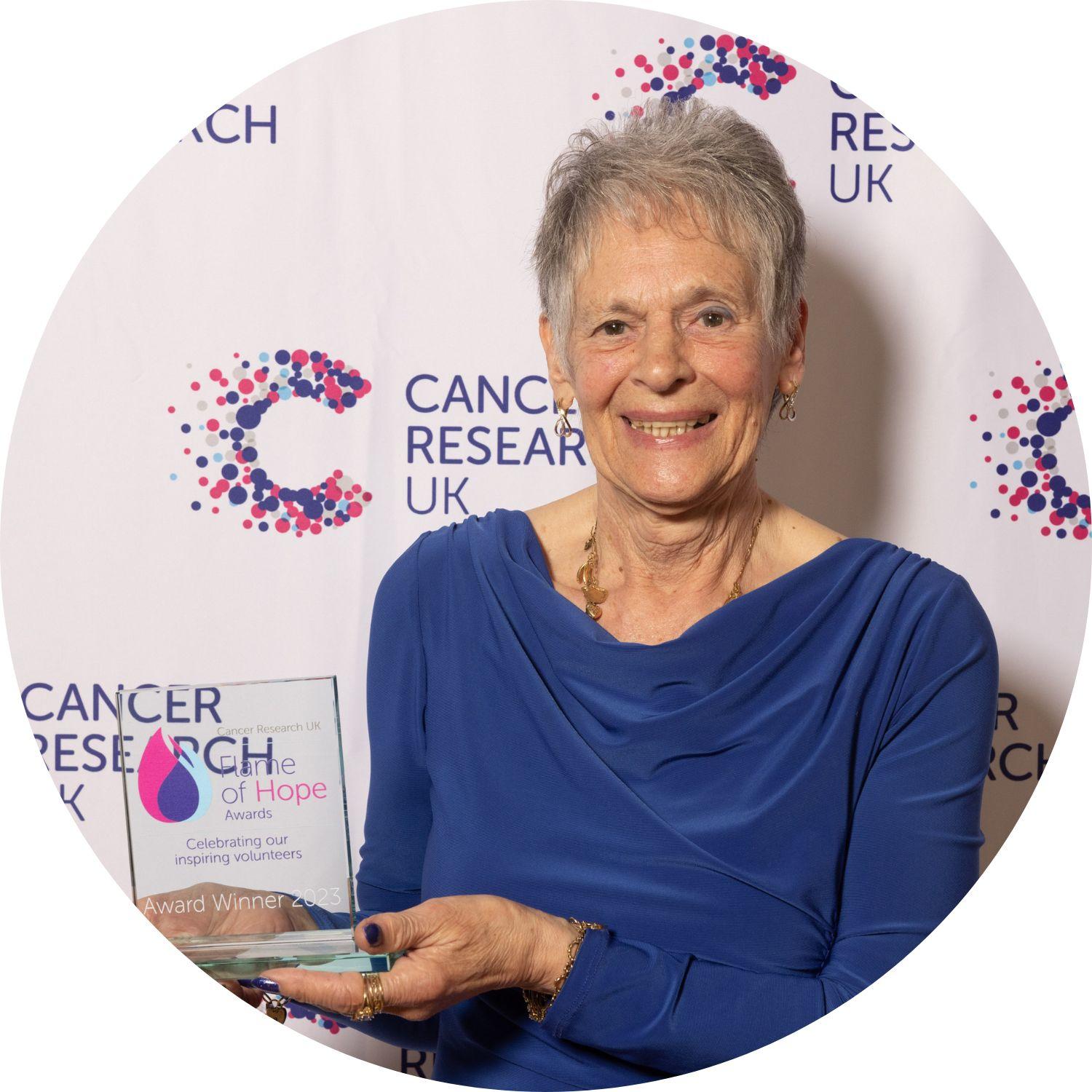 Muriel holding her Flame of Hope trophy