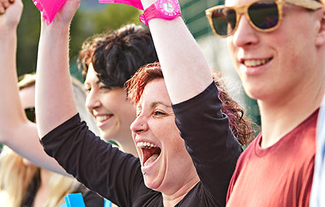 A group of people cheer on with inflatable clappers