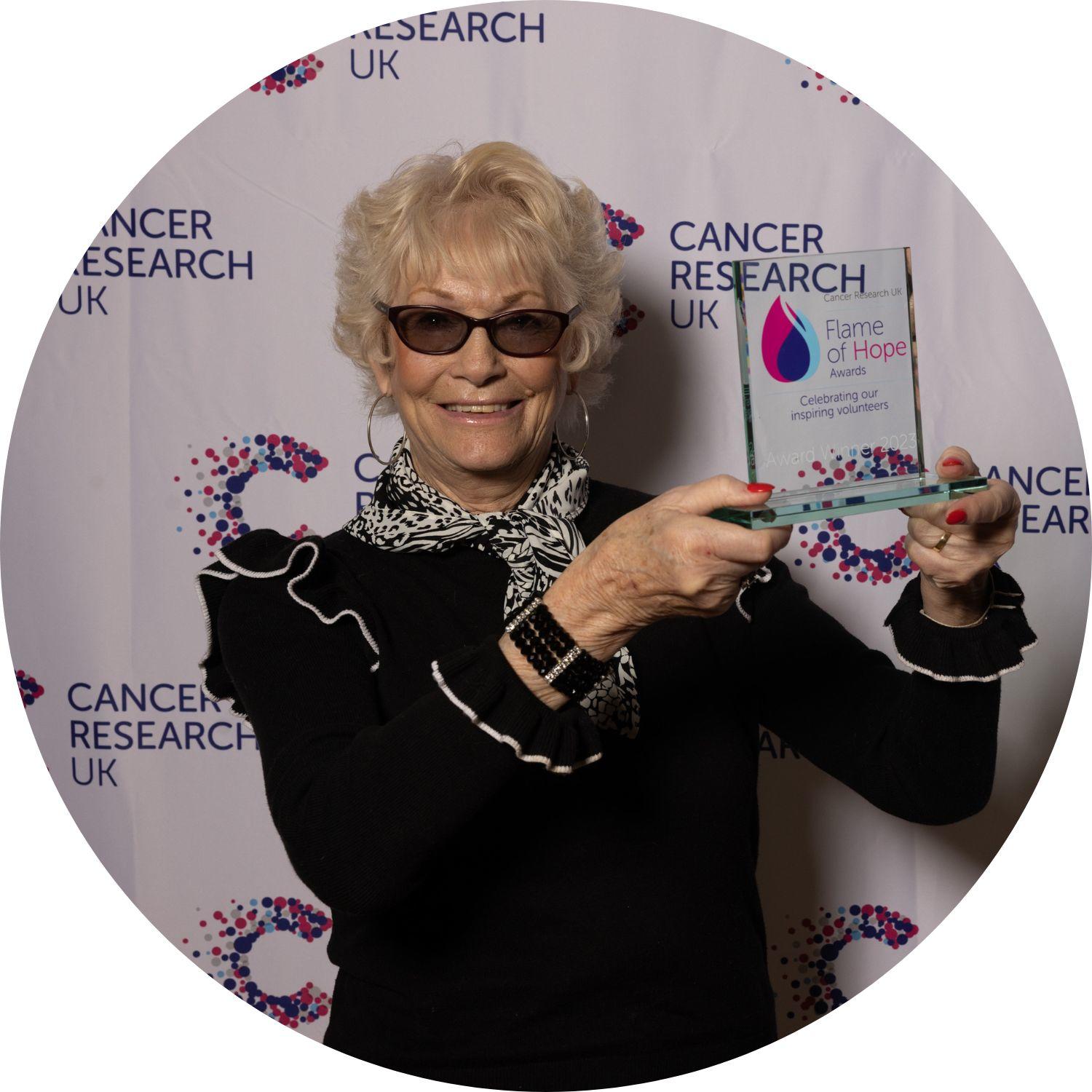 Patricia holding her Flame of Hope trophy
