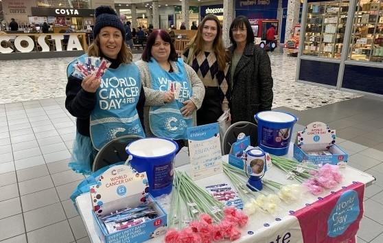 4 volunteers fundraising at a table in a shopping centre