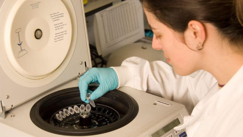 Researcher loading samples into a centrifuge