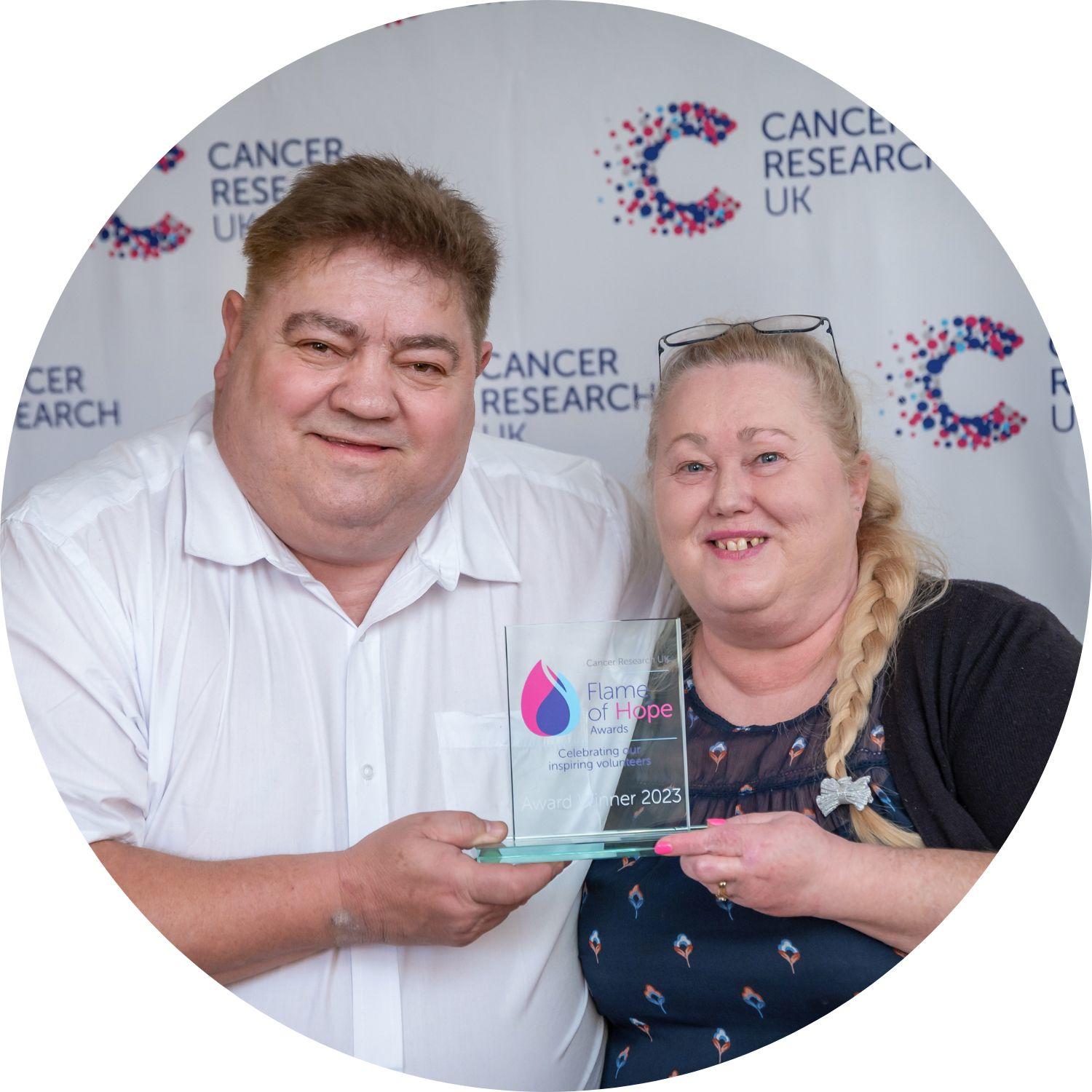 Owen and Sandy holding their Flame of Hope trophy