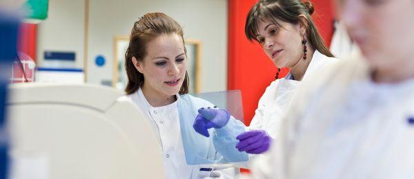 2 female researchers in a lab wearing lab coats