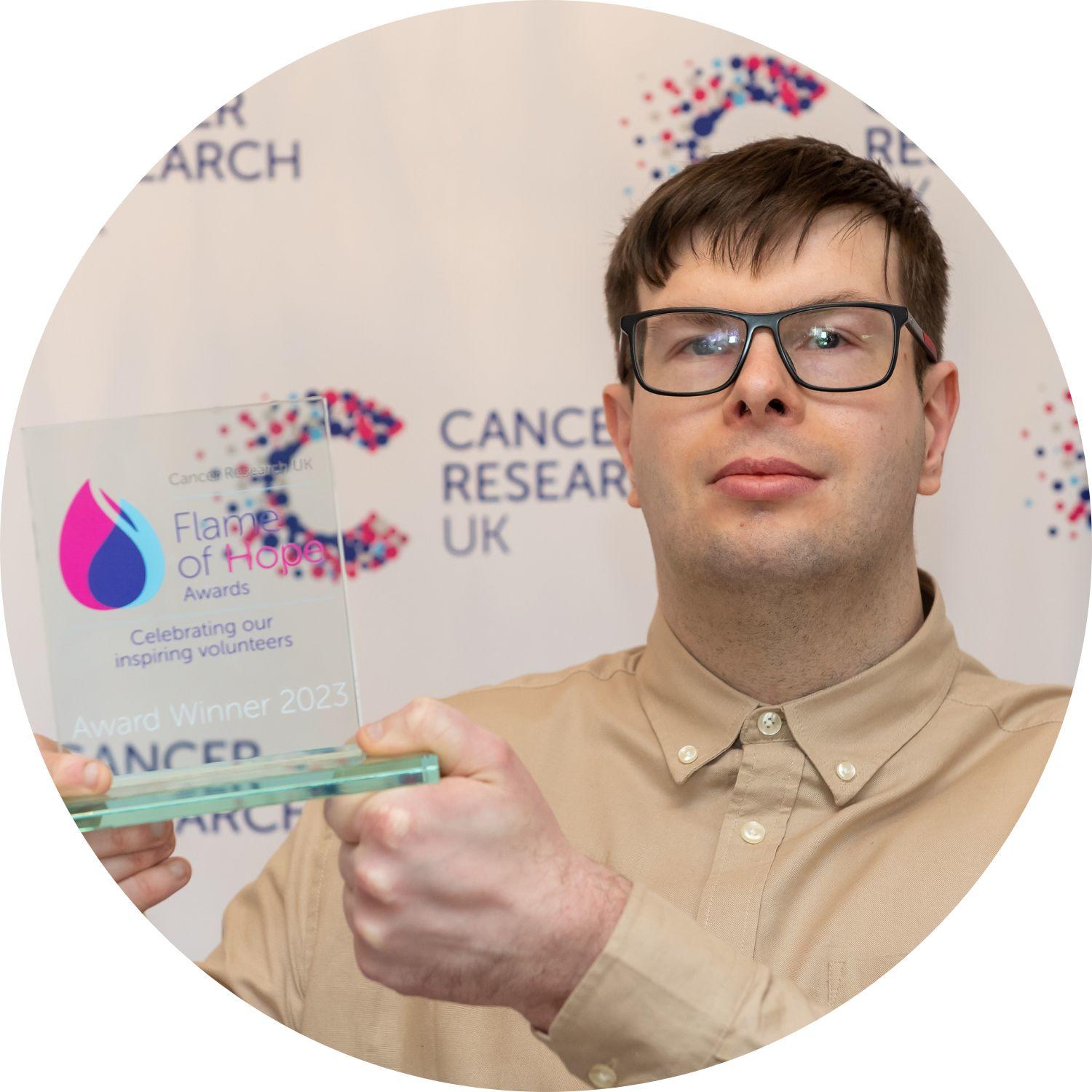 Scott holding a Flame of Hope trophy