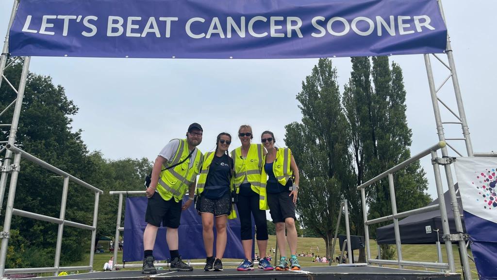 Photo of the Race for Life participants with a man holding a hand of a boy smiling in the middle