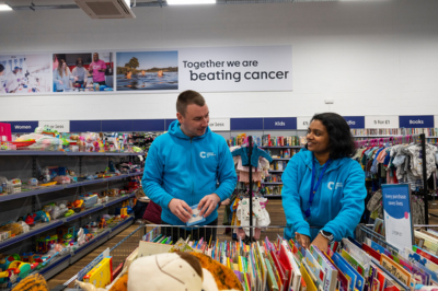 Two volunteers sorting through children's books in a shop