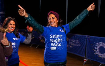 Woman smiling at the camera with both hands up at Shine Night Walk