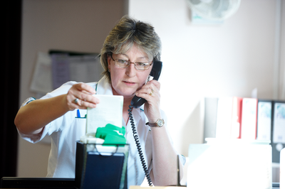 A cancer nurse looks at some results whilst on the telephone