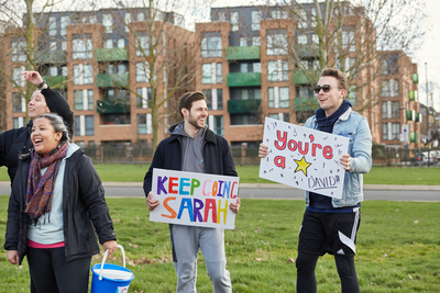 Supporters holding signs while cheering at a CRUK event