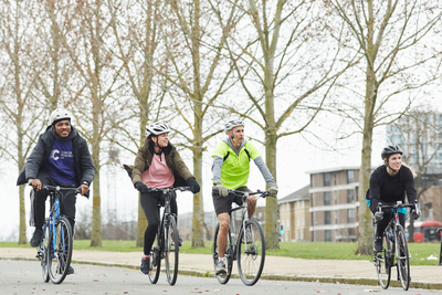 CRUK event participants cycling through a park