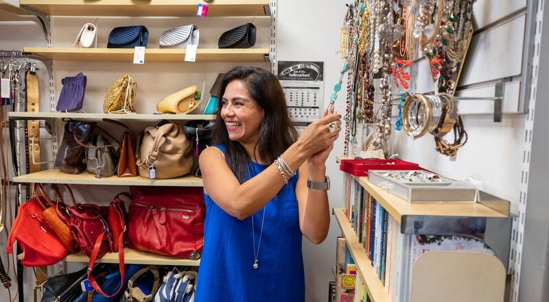 Woman arranging jewellery and accessories inside CRUK store