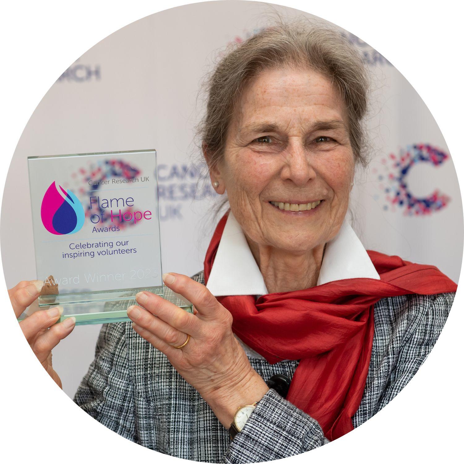 Susan holding a Flame of Hope trophy