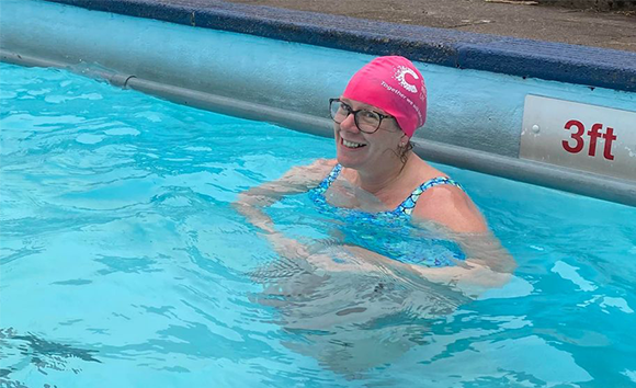 Lady swimming in CRUK swimming hat