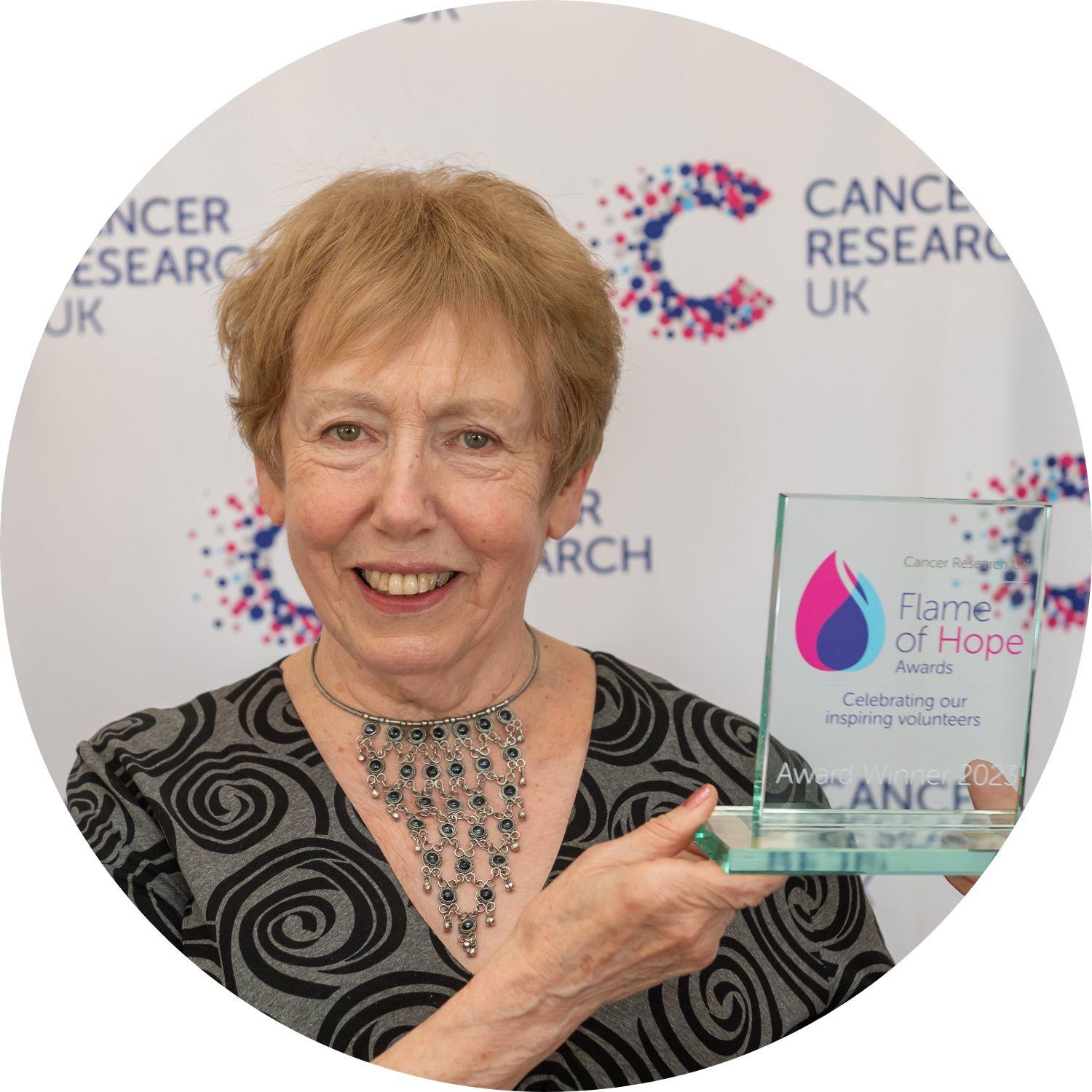 Sylvia holding a Flame of Hope trophy