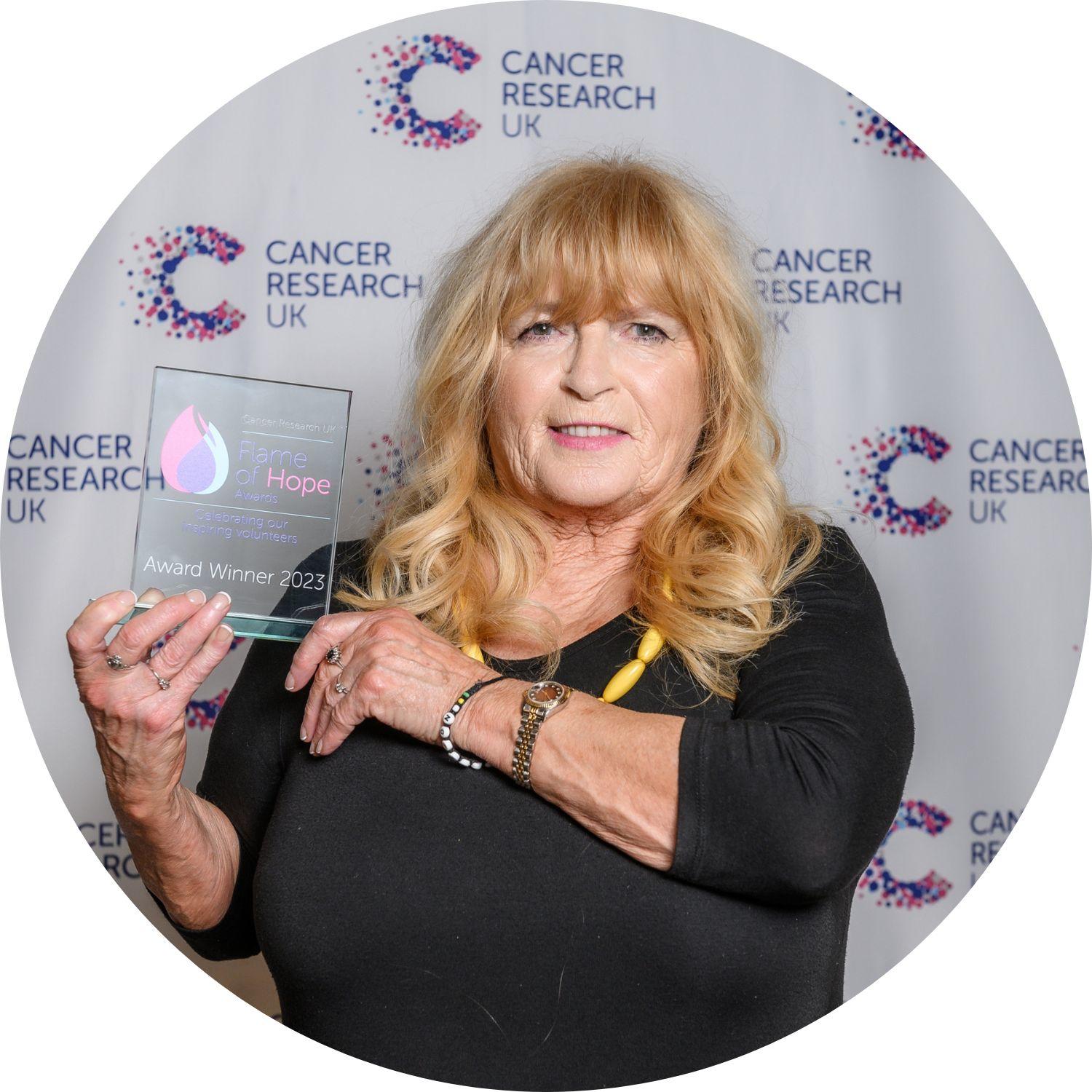 Teresa holding a Flame of Hope trophy