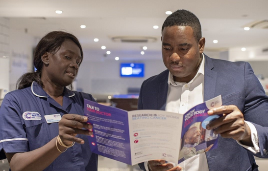 Cancer Awareness Nurse showing a CRUK leaflet to an employee taking part in the Workplace programme