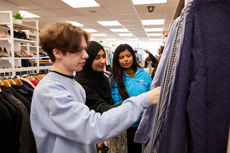 Volunteers looking at clothing on the rails