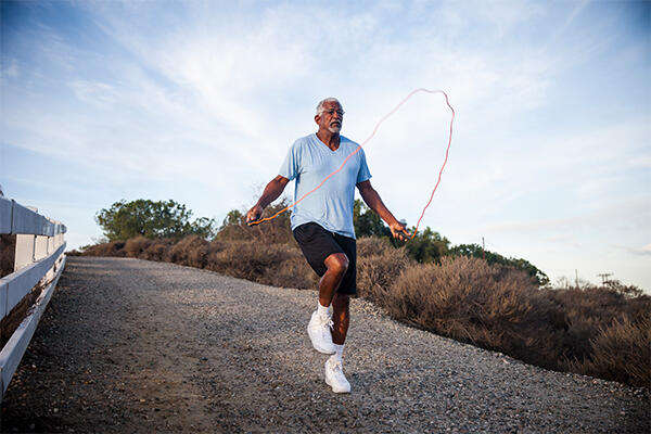 Older man skipping on road