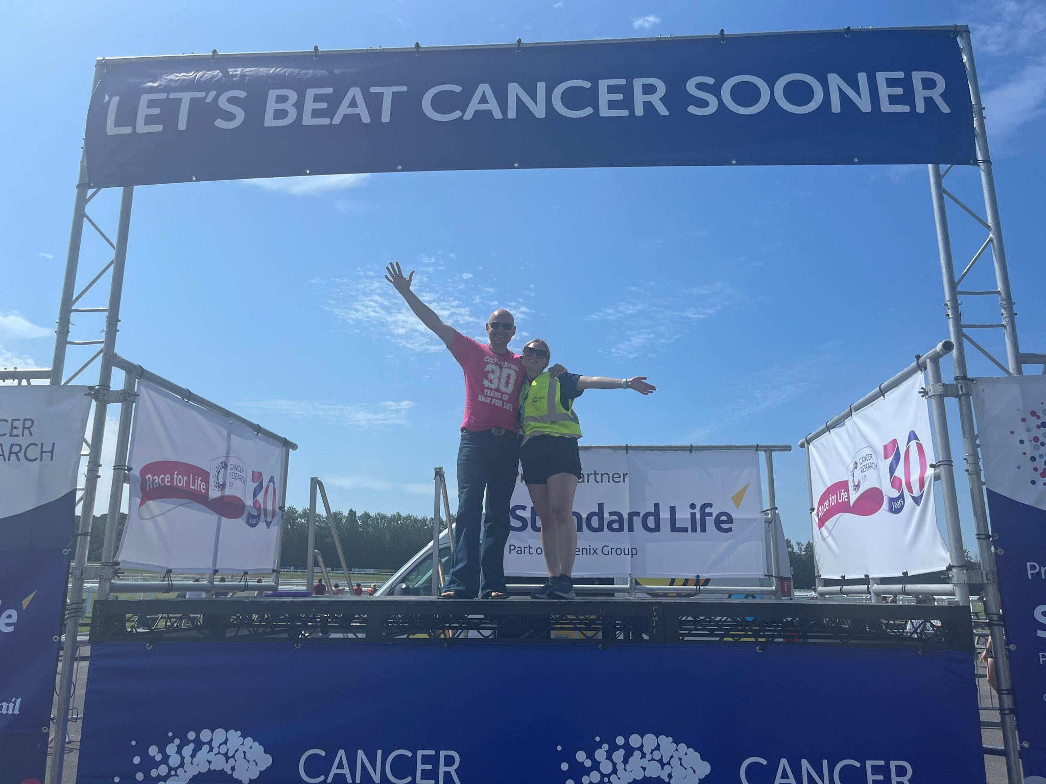 Photo of the Race for Life participants with a man holding a hand of a boy smiling in the middle
