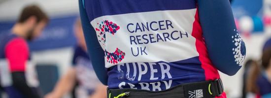 Runner wearing a CRUK vest with back to camera at a post race event.