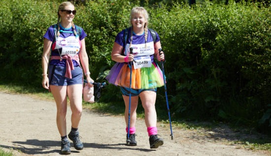 Two Big Hike ladies hiking with walking sticks and smiling