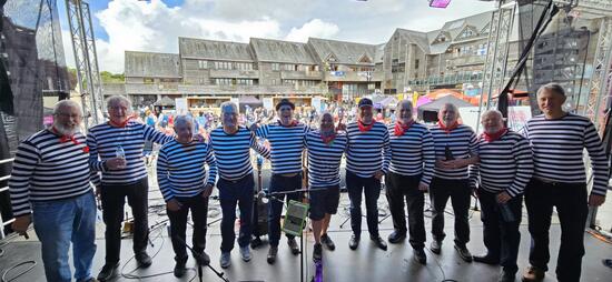 The Sloop Groggy Dogs on stage in stripy black and white tops