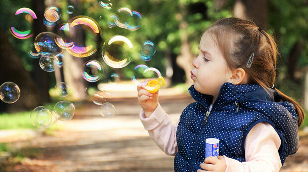 little girl blowing bubbles