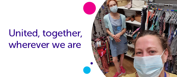 Two shop volunteers in masks socially distancing on the shop floor