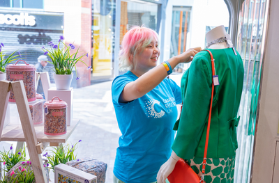 1 volunteer putting on clothes for mannequin