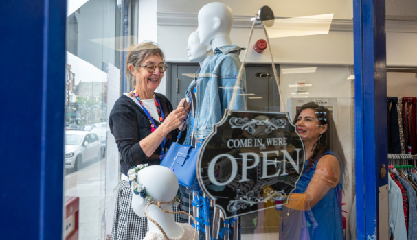 Two women smiling in a shop window