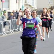 Woman waving and running in CRUK branded top