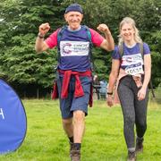 Two hikers at the Big Hike finish line waving and smiling
