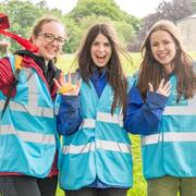 Three female volunteers cheering at race for life
