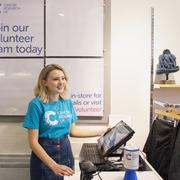 Female shop volunteer working at the till