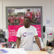Male volunteer standing at the till on a CRUK shop