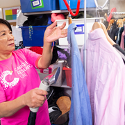 Female volunteer steaming clothes in the stock room
