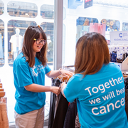 2 volunteers in shop, 1 person handing items to another