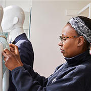 Portrait of a volunteer dressing a mannequin in a charity shop